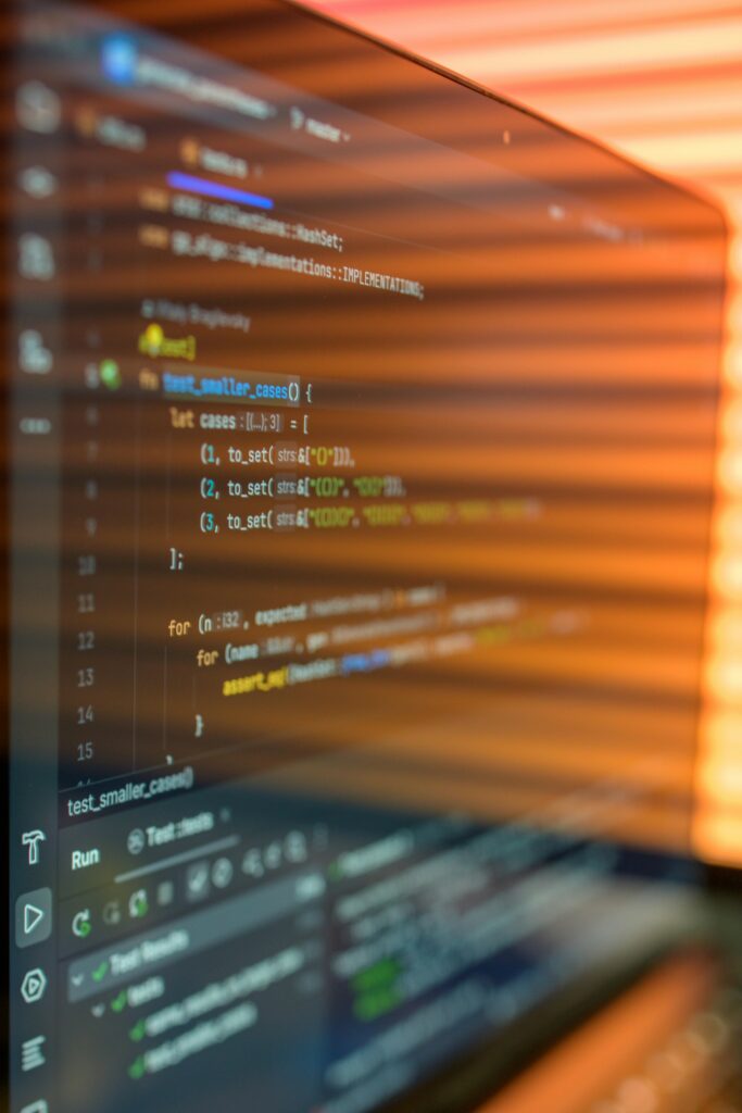 Close-up image of a computer screen displaying colorful programming code in a warm setting.